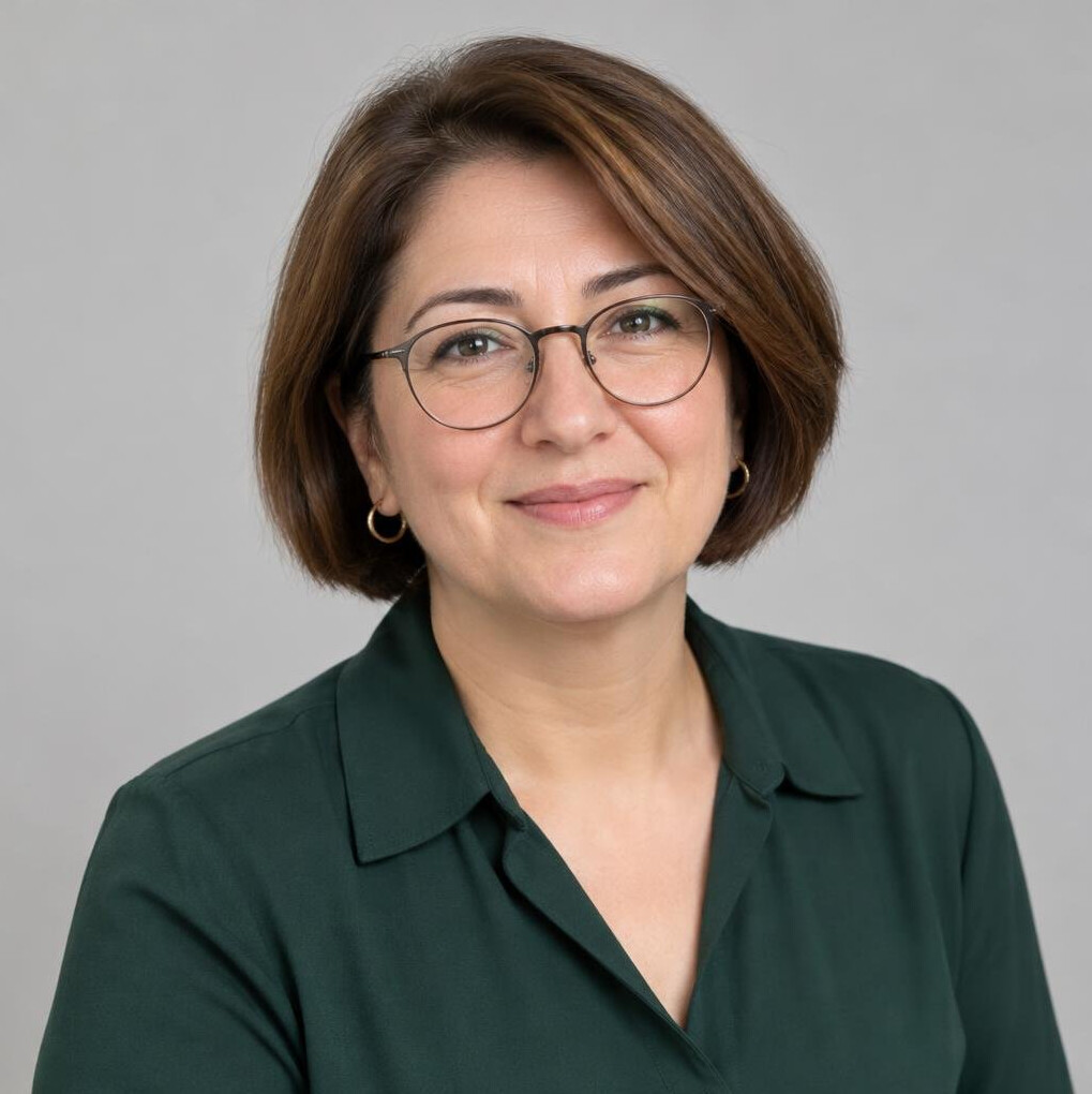 Portrait of a Turkish woman in her 40s with short hair and glasses