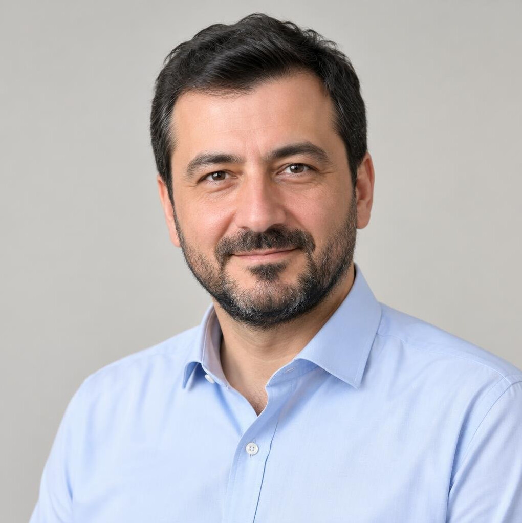 Portrait of a Turkish man in his 40s with short dark hair and a beard